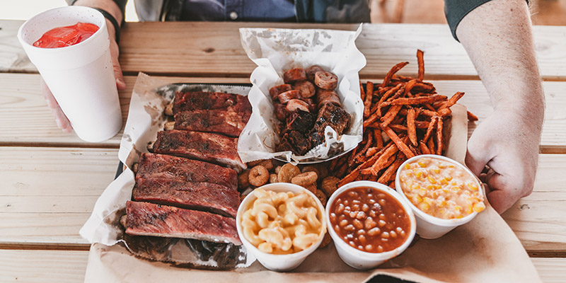 Tray of ribs and barbecue on a picnic table